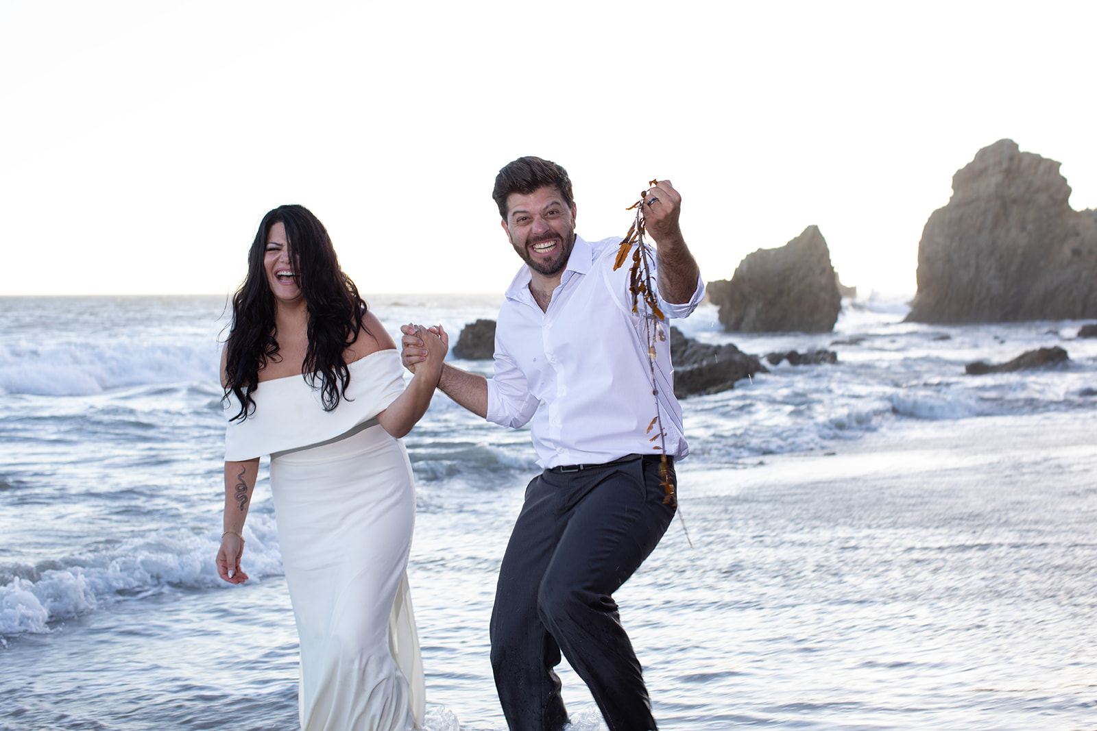 Sari holding up seaweed while Cam laughs
