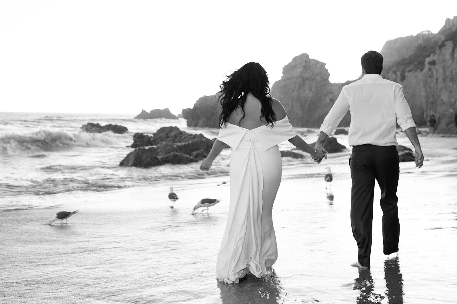 Cam and Sari walking hand in hand along the shore